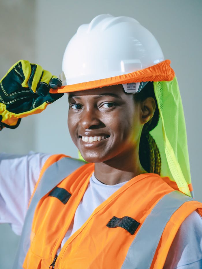 Confident female worker wearing safety equipment at a construction site.